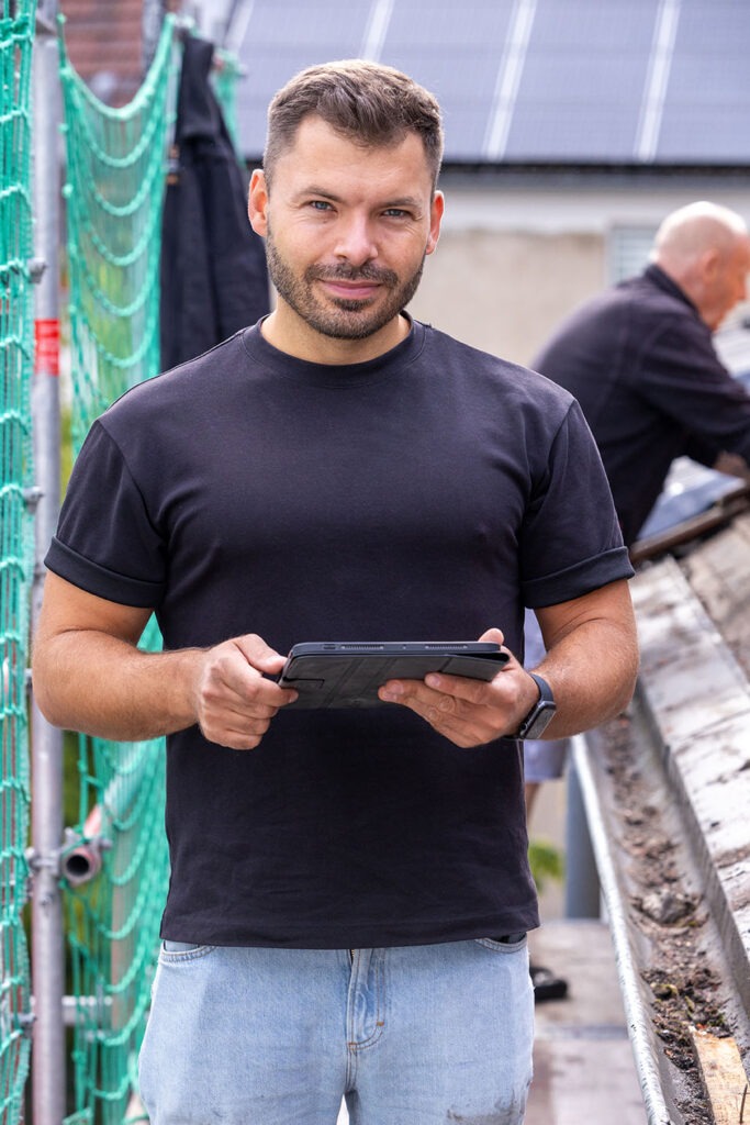 Jasper Gromoll bei der Baubegleitung einer Dachsanierung in die Kamera schauend IMG_0809