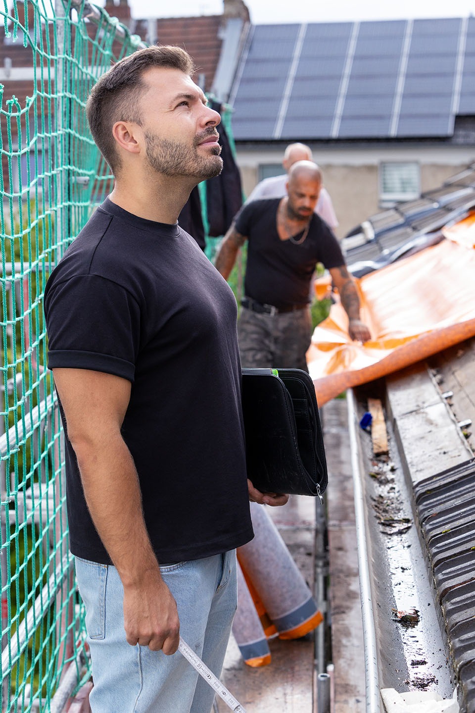 Jasper Gromoll bei der Baubegleitung einer Dachsanierung prüfend nach oben schauend