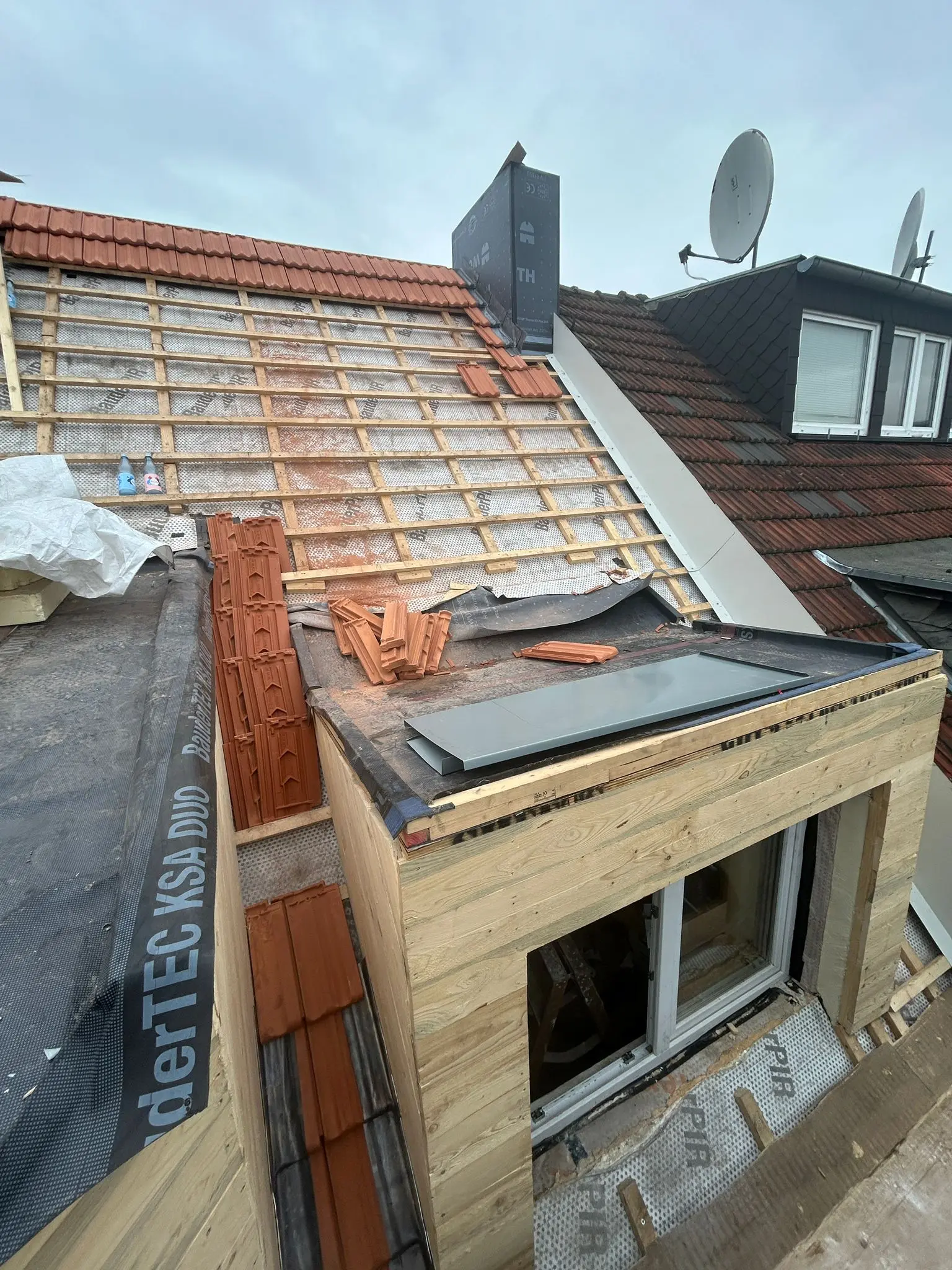 Dachsanierung unter Denkmalschutz: Neue Ziegeleindeckung und Dachfenster im Einbau